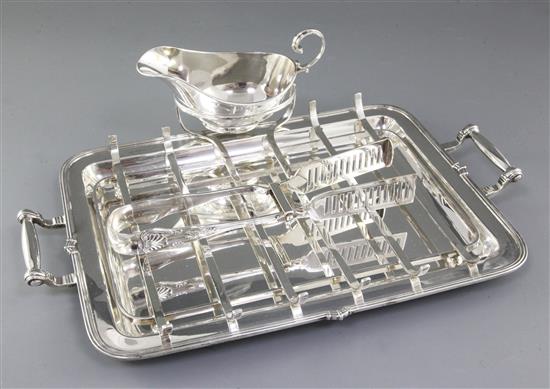A 1930s silver asparagus draining dish with asparagus servers and sauce boat, by Goldsmiths & Silversmiths Co, tray length